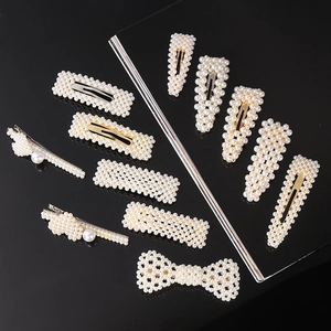 Detailed set of twelve pearl hair clips in geometric shapes on a black reflective background