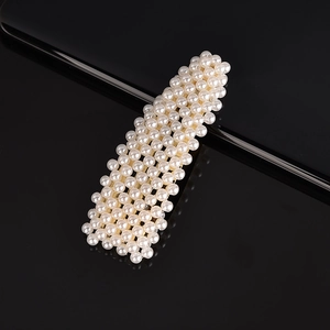 Close-up of elegant handmade white pearl hair clip with premium reflective finish