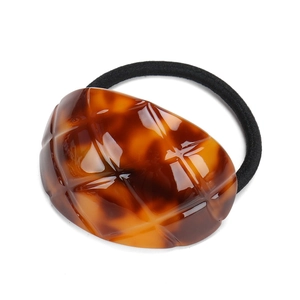 Detail of a large oval tortoiseshell pattern acetate hair tie with a black elastic band