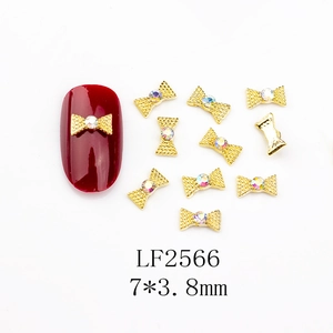 Vue macro des bijoux d'ongles nœuds en alliage doré 7x3,8mm avec strass étincelant