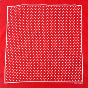 Flat lay of a red cotton bandana with white polka dots and 100% cotton print text