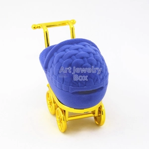 Detail of baby stroller jewelry box with blue velvet texture and gold plated frame