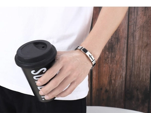 Men's adjustable silicone cross bracelet in black and silver shown on a male wrist