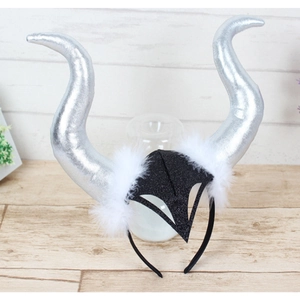 Detailed view of silver fantasy horns with black glitter base and white faux fur trim