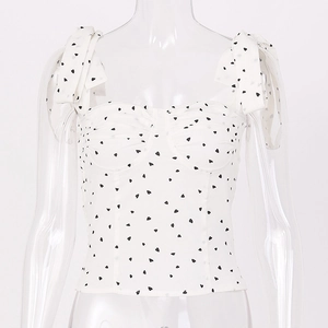 Detail des weißen Camisole-Tops mit schwarzem Herz-Print und Schleifen-Schultergurten