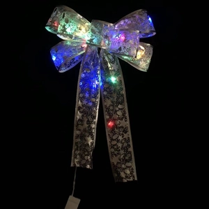 Detail of silver Christmas bow with built-in multicolor LED lights and battery box