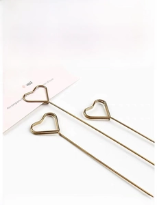 Detailed view of heart-shaped gold floral card holder pick for bouquet arrangements