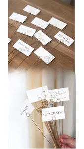 Close-up of gold metal floral card holder picks with elegant circular clip detail