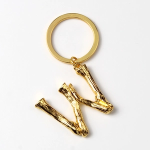 Detail of gold letter W keychain with creative branch texture and standard keyring