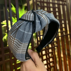 Detail of the twisted plaid headband with grey and brown fabric and non-slip lining