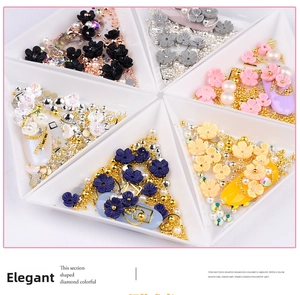 Detailed macro view of 3D shell flower nail charms with gold beads and pearls in white trays