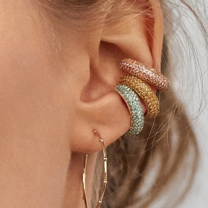 Detail of layered gold bamboo hoop earrings with colorful micro-pave zircon ear cuffs