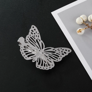 Detail of silver hollowed butterfly hair clip showing metallic texture and texture wing design