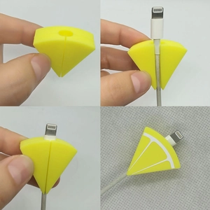 Detail view of lemon slice cable protector showing installation process on white cord