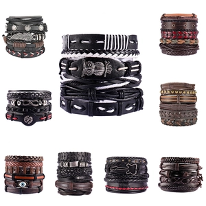 Set di bracciali multistrato in pelle con ciondoli a forma di gufo e piuma su sfondo bianco