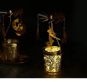 Close-up of golden rotating carousel candle holder with moon cat and fairy charms