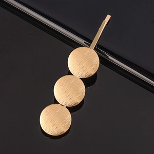 Barrette à cheveux dorée minimaliste avec trois disques en métal brossé connectés verticalement