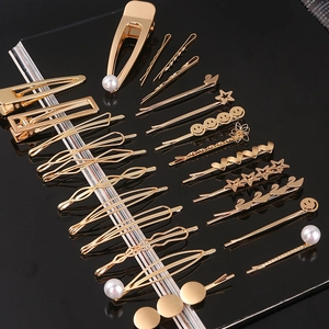 Detailed close-up of golden metal hair clips with pearls, stars, and heart designs