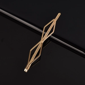 Barrette à cheveux géométrique dorée minimaliste avec finition polie sur fond noir