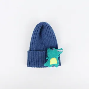 Detaillierte Nahaufnahme der marineblauen Strickmütze mit grünem Krokodil-Aufnäher