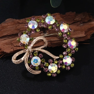 Macro view of crystal gemstone bow brooch on natural wood showing the pin clasp and stones