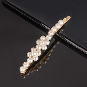 Detail of elegant gold hairpin with double rows of cream pearls and polished finish