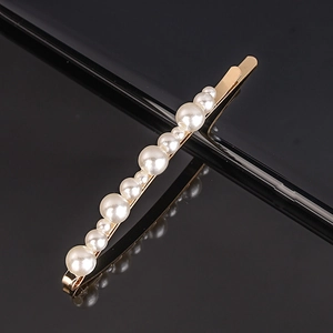 Macro view of gold alloy hairpin featuring alternating pearls on a sleek black background