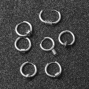 Macro shot of silver stainless steel hoop earrings with various geometric pendants
