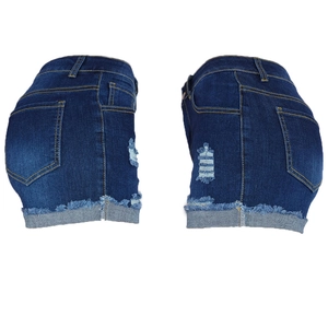 Detailed close-up of distressed denim shorts with ripped details and frayed raw hem