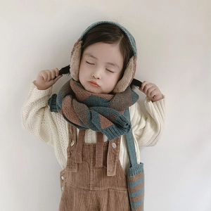 Detail view of children's knit set showing blue-green striped scarf and earflap hat