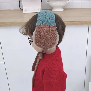 Detail of cable knit kids earmuffs with plush lining and dual-tone color design