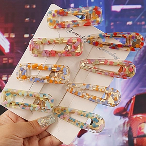 Close-up of 8-piece leopard print acrylic hair clip set with gold metal clips on display