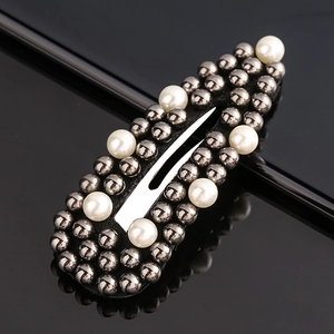 Detail showing dark gray metal beads and white faux pearls on a stylish snap hair clip