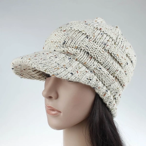 Detail of chunky knit ponytail baseball cap in cream with multicolored yarn texture