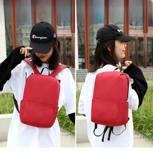 Detail view of the red casual backpack showing durable oxford fabric texture and zippers