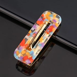 Close-up of acetic acrylic hair clip with colorful fragments and golden alloy clip