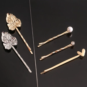 Detailed view of gold and silver hair clips featuring pearls, rhinestones, and leaf designs