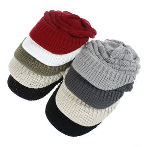 Detail of cable knit beanies in various colors showing thick acrylic yarn texture