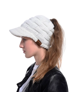 Detailed texture of white cable knit ponytail baseball cap with brown leather logo patch