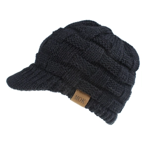 Detail of black thick cable knit beanie with visor showing leather brand label and texture