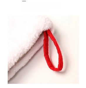 Dettaglio di una calza natalizia in peluche bianco con un robusto passante rosso