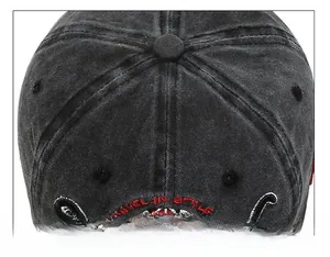 Detailed view of red and white 'Travel in Style' embroidery on a washed black cotton cap