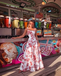Detail of red floral print dress with thin straps and layered bohemian style hemline
