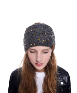 Détail d'un bandeau en maille torsadée grise avec taches colorées sur modèle
