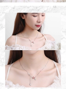 Detail view of silver moonstone unicorn necklace featuring a crescent moon and pink gemstone