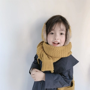 Detail showing ginger yellow knitted hat earmuffs and scarf set worn by a child
