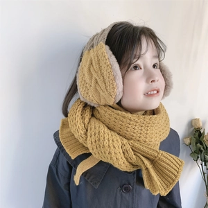 Detail of child wearing ginger yellow knitted scarf and plush ear muff hat set