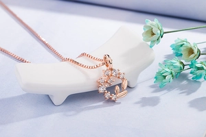 Close-up of rose gold daisy wreath pendant necklace with sparkling white zircons