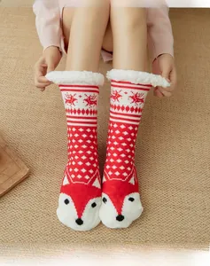 Detailed knit pattern of red winter socks with white lamb wool lining and festive reindeer
