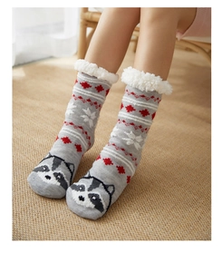 Detail of warm grey knit floor socks with white faux fur cuff and raccoon pattern